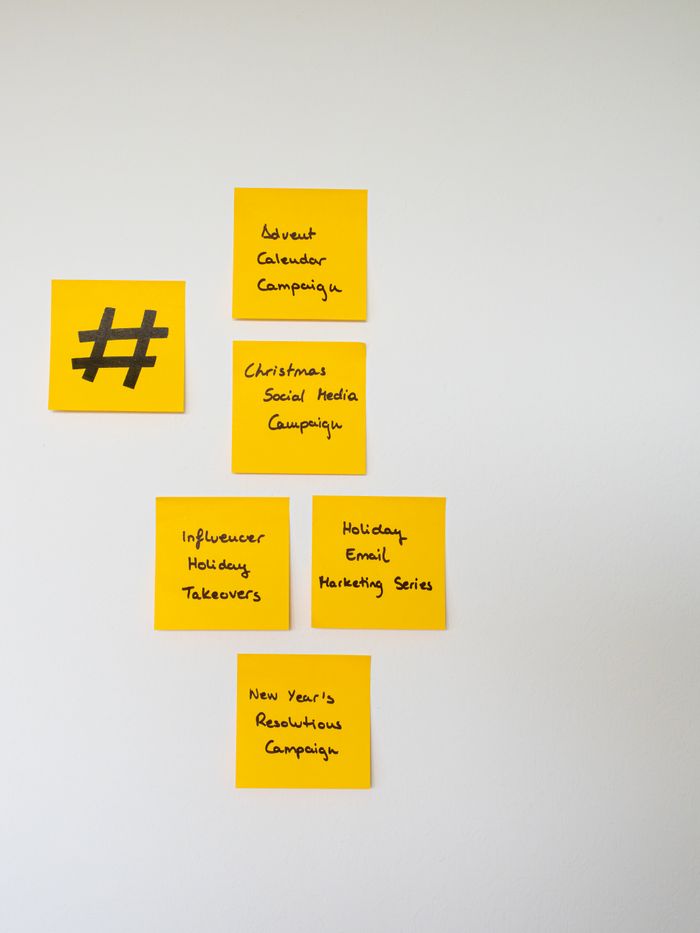 creative-01 Yellow sticky notes with handwritten marketing campaign ideas on a wall.